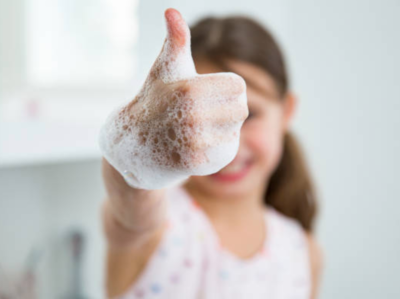 girl washing hands to avoid the flu and covid-19